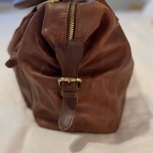 Leather bag with multiple pockets and extra strap. Cute lining inside.